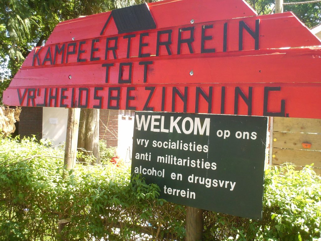 sign at the entrance of the campsite, stating it is an antimlitarist, alcohol- and drugfree place.